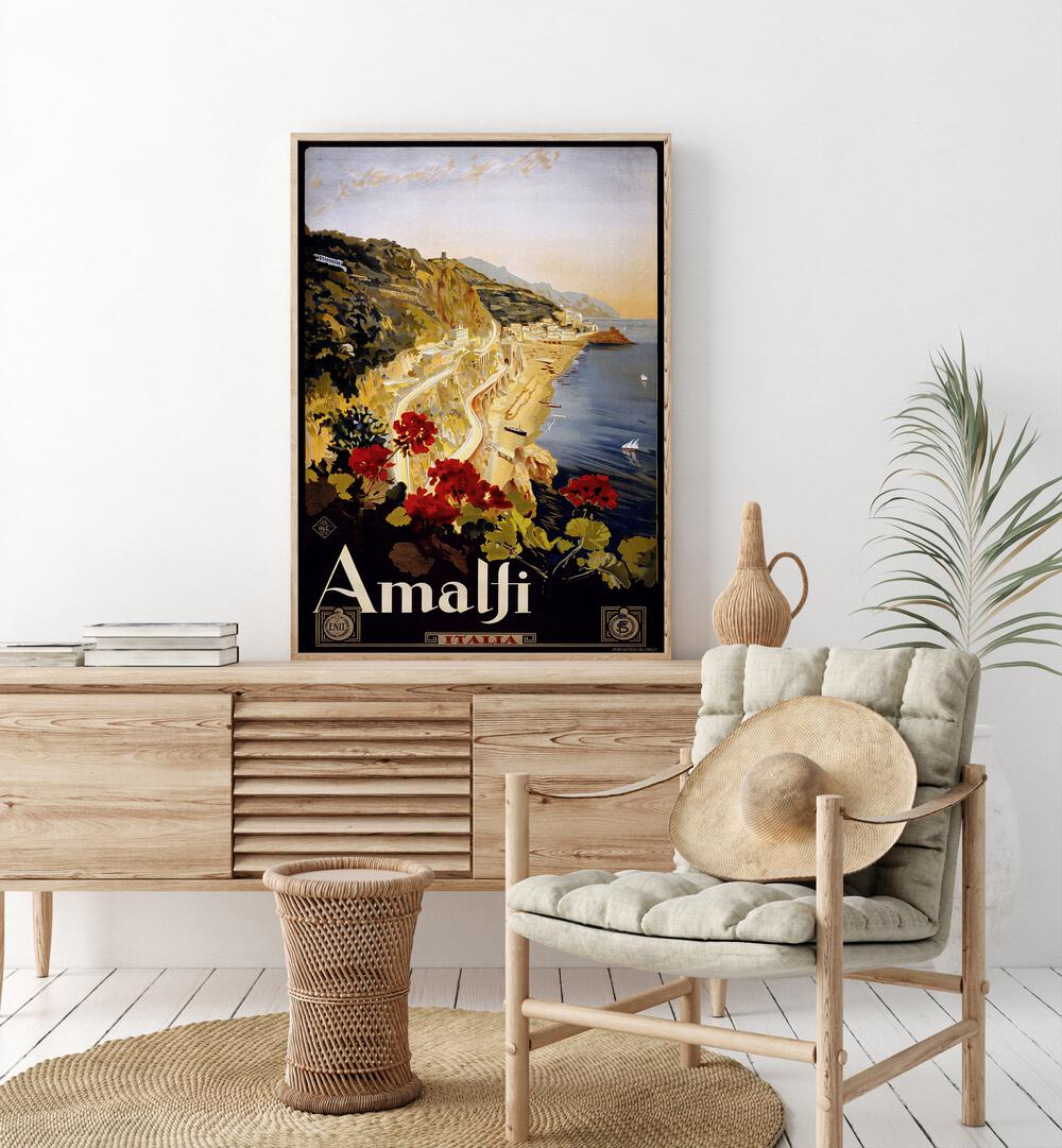 Amalfi Coast  Retro Travel Posters in Oak Wood Plain Frame placed on a console table behind a chair