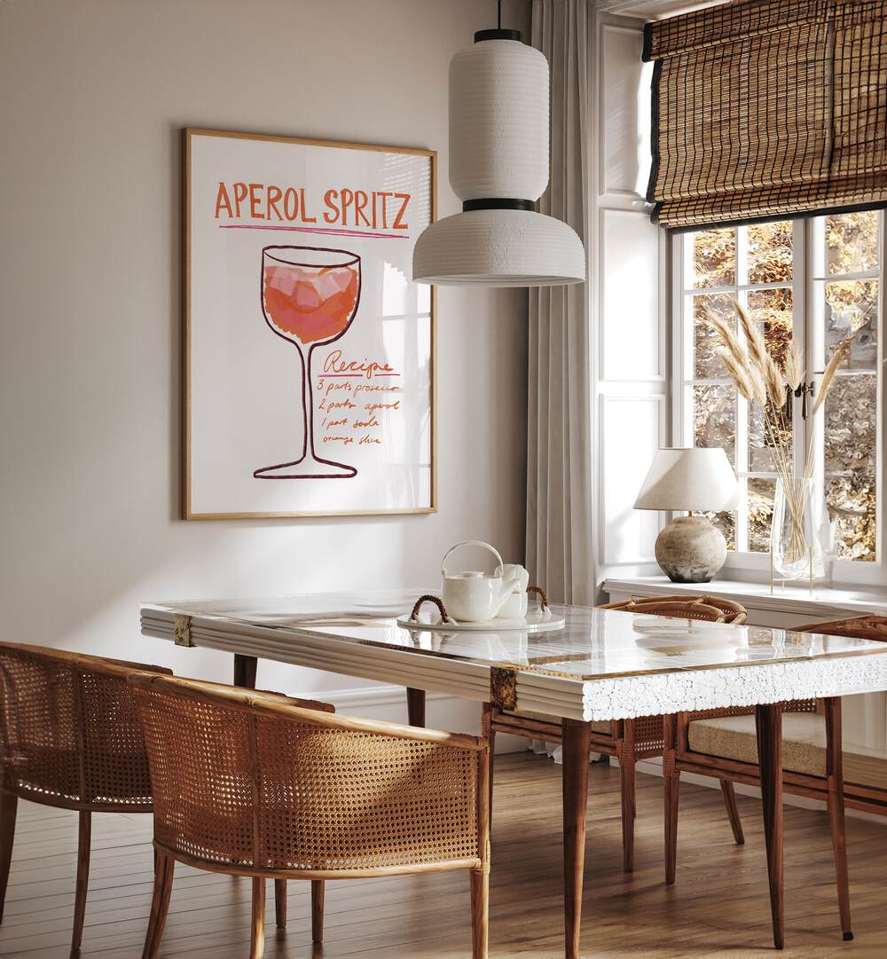 Aperol Spiritz by Athene Fritsch Cafe Art Prints Cafe Posters in Oak Wood Plain Frame placed on a wall in a dining room area beside a window and behind a dining table