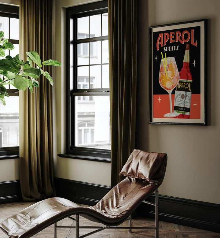 Aperol Spritz Black Cafe Art Prints Cafe Posters in Black Plain Frame placed on a living room wall beside a window and behind a chair