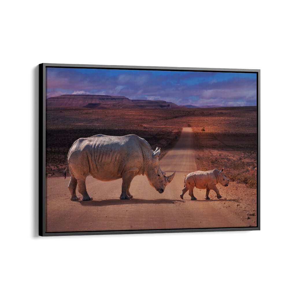 Rhinos Crossing, Photography Prints showcase a mother and calf rhino on a scenic dirt road, celebrating wildlife beauty.