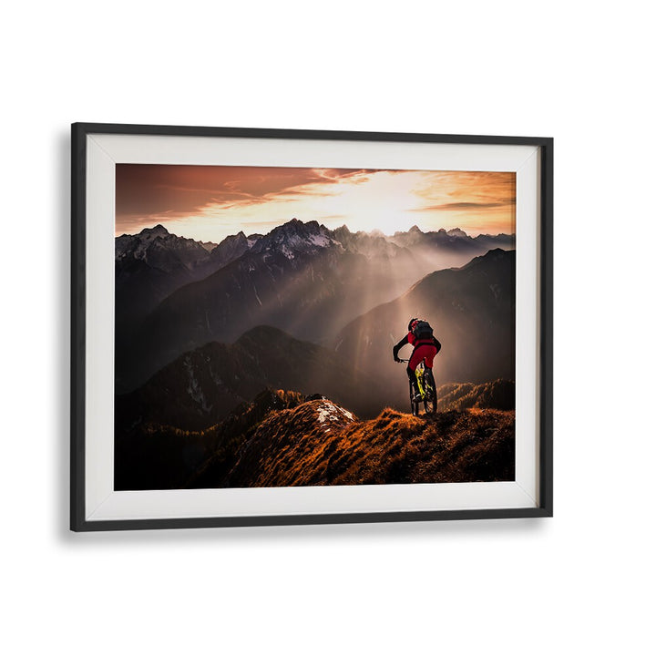 Mountain biker silhouetted against a sunset, showcasing the thrill of adventure in JUST RIDE, PHOTOGRAPHY PRINTS.
