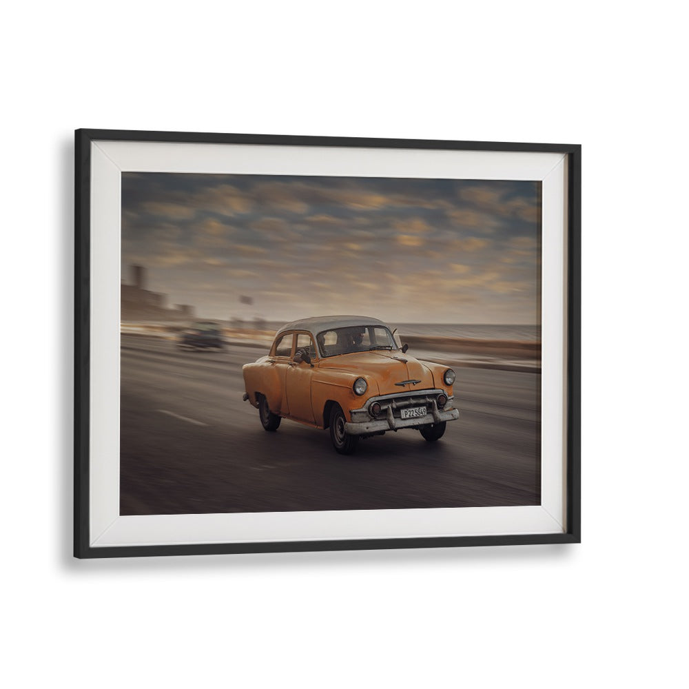Capture the essence of street life with MALECON VII, PHOTOGRAPHY PRINTS showcasing a classic yellow car in motion.