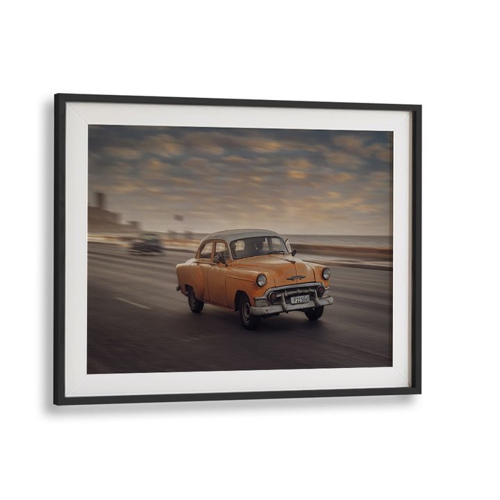 Capture the essence of street life with MALECON VII, PHOTOGRAPHY PRINTS showcasing a classic yellow car in motion.