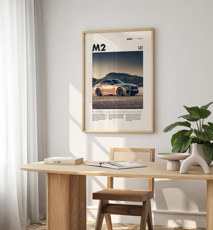 BMW M2 G87 Car Posters Automotive Wall Art Prints in Oak Wood Plain Frame placed on a White  Colored Wall near a Study Table in a Workspace in the Drawing Room