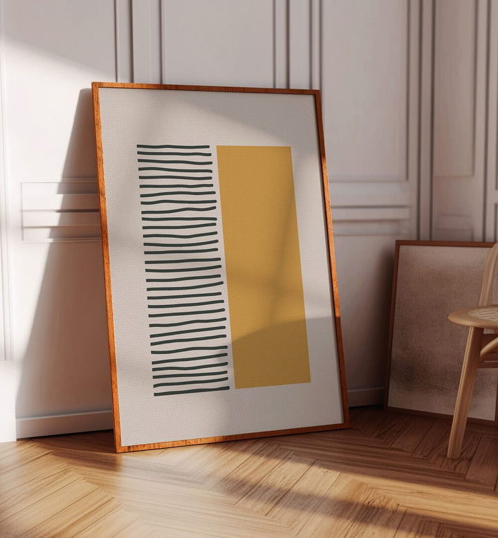 Bold Yellow And Black Stripes Geometric Art Painting Artwork in plain oakwood frame on a wooden floor beside a chair