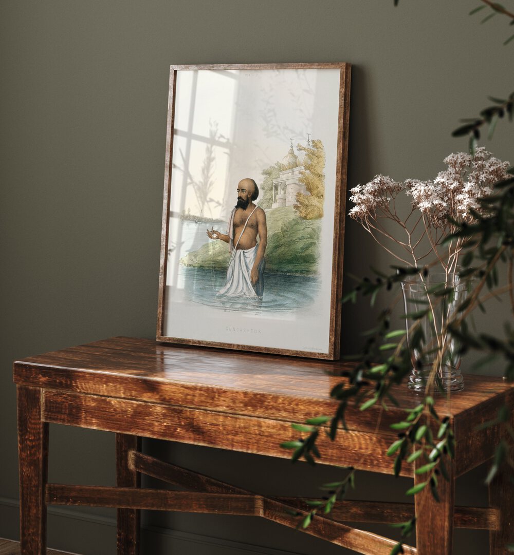 Brahmin's First Ceremony Artwork Indian Art Painting Artwork in plain oakwood frame on a table next to a flower pot