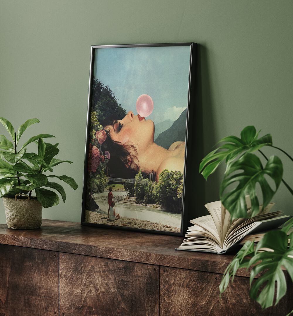 Bubble Gum Girl Surreal Art Painting Artwork in plain black frame above a console table beside a book and a plant