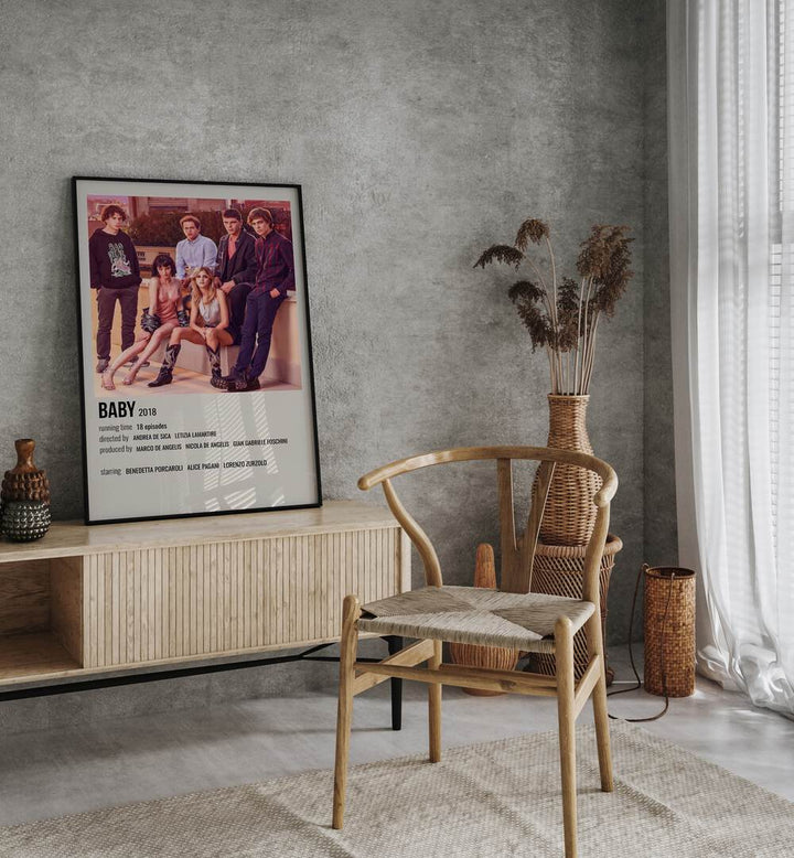 Baby 2018 Movie Posters in Black Plain Frame placed on a table beside oakwood chair