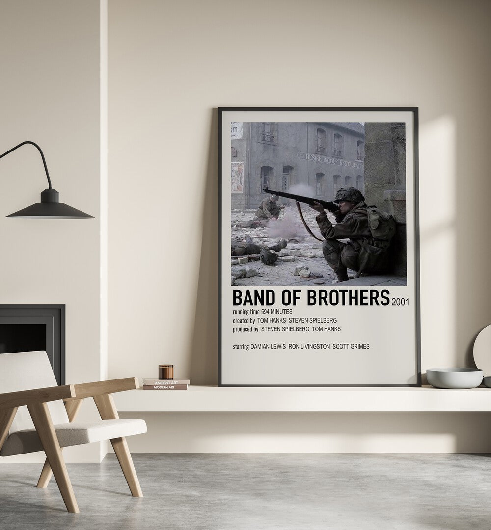 Band Of Brothers 2001 Movie Posters in Black Plain Frame place on a wall behind a chair beside lamp