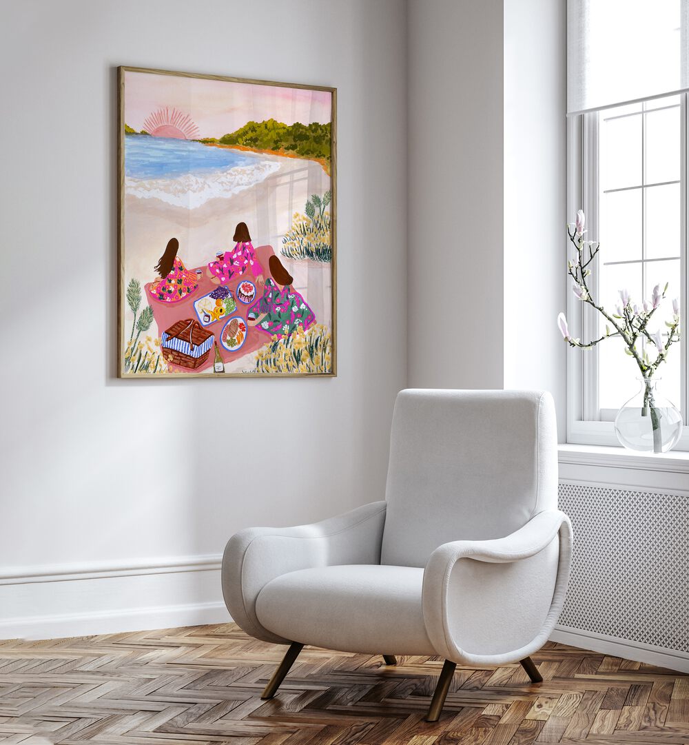 Beach Picnic By Sarah Gesek Coastal Wall Art Prints in Oak Wood Plain Frame placed on a white wall beside a chair and a window