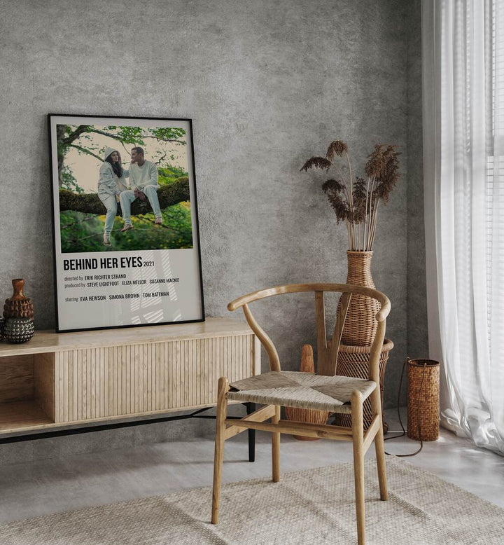 Behind Her Eyes 2021 Movie Posters in Black Plain Frame placed on a table beside oakwood chair