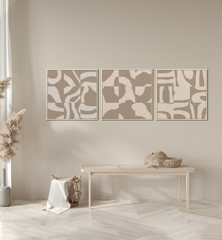 Beige Monochromes Set Set Of 3 Paintings in Oak Wood Plain Frame placed on a wall behind a table and beside a plant