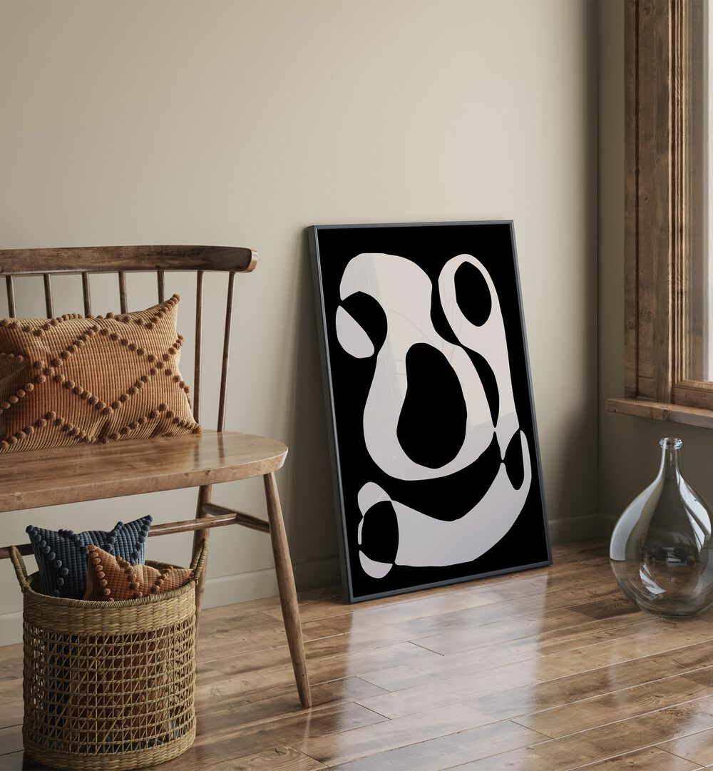 Black And Beige II By Preayna Abstract Art Paintings in Black Plain Frame on floor beside a chair