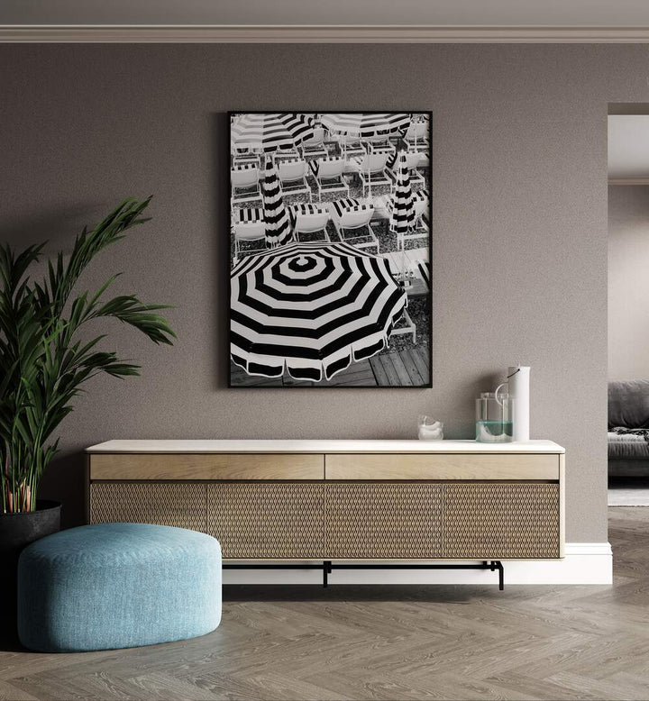 Black and White Beach Umbrellas I By Grace Digital Art Co Beach Prints in Black Plain Frame placed on a wall behind a console table