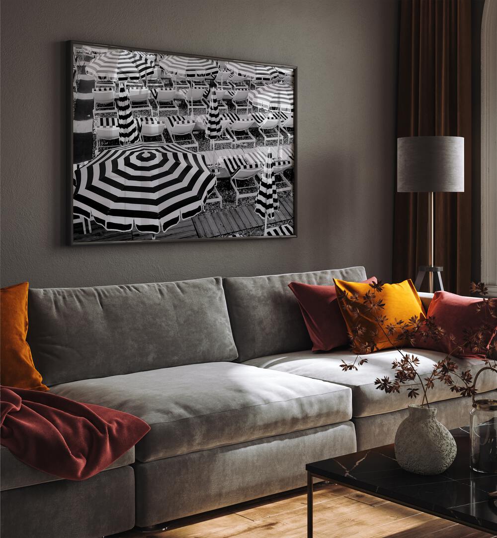 Black and White Beach Umbrellas II By Grace Digital Art Co Beach Prints in Black Plain Frame placed on a wall behind a grey sofa for living room