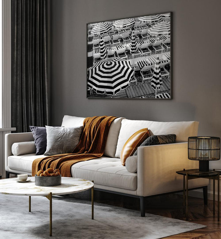 Black and White Beach Umbrellas II By Grace Digital Art Co Beach Prints in Black Plain Frame placed on a wall behind a white sofa for living room