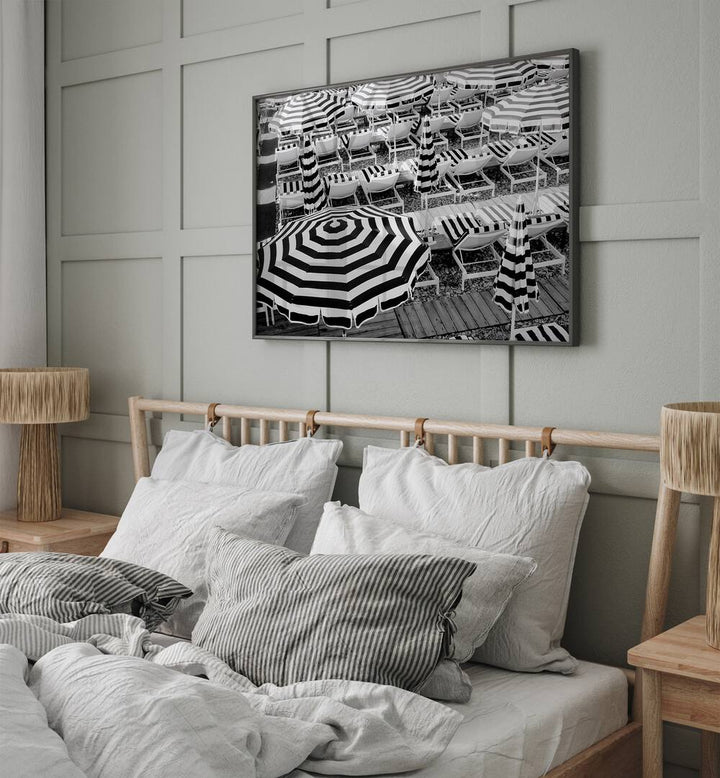 Black and White Beach Umbrellas II By Grace Digital Art Co Beach Prints in Black Plain Frame placed on a wall behind a bed for bedroom