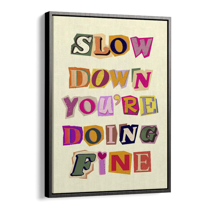 Framed artwork featuring the inspirational phrase "SLOW DOWN YOU'RE DOING FINE" in vibrant colors. Perfect for decor.