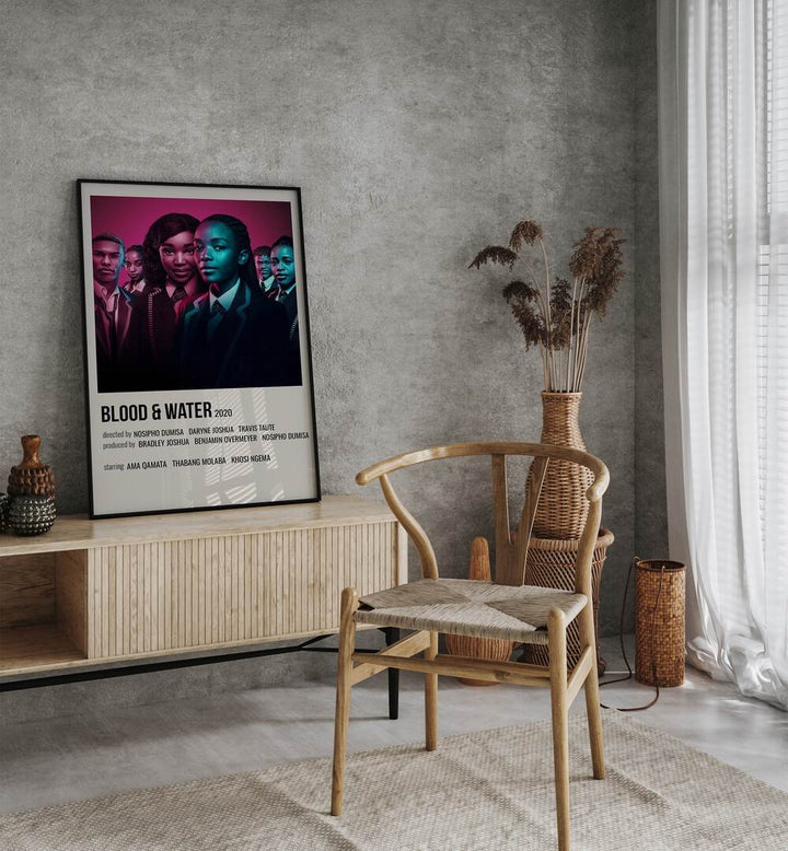 Blood Water 2020 Movie Posters in Black Plain Frame placed on a table beside oakwood chair