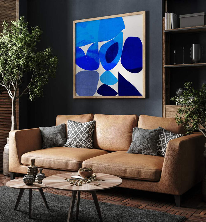 Blue Abstract Kopie III By Ana Rut Bre Abstract Art Abstract Paintings in Oak Wood Plain Frame placed on a Dark Grey Colored Wall near a Brown Sofa in the Living Room