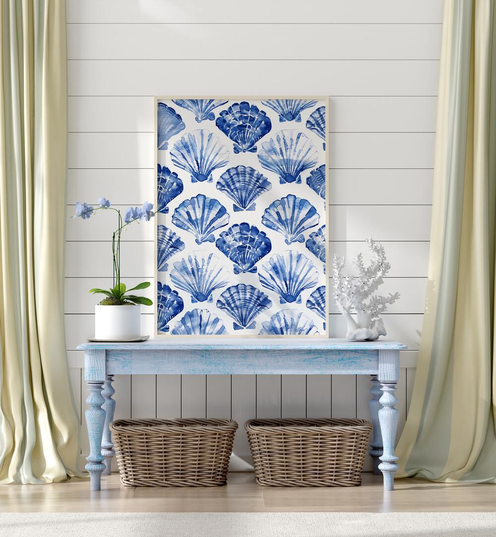 Blue Ocean Bivalve Beach Prints Coastal Wall Art in White Plain Frame placed on a blue table beside a plant and a showpiece