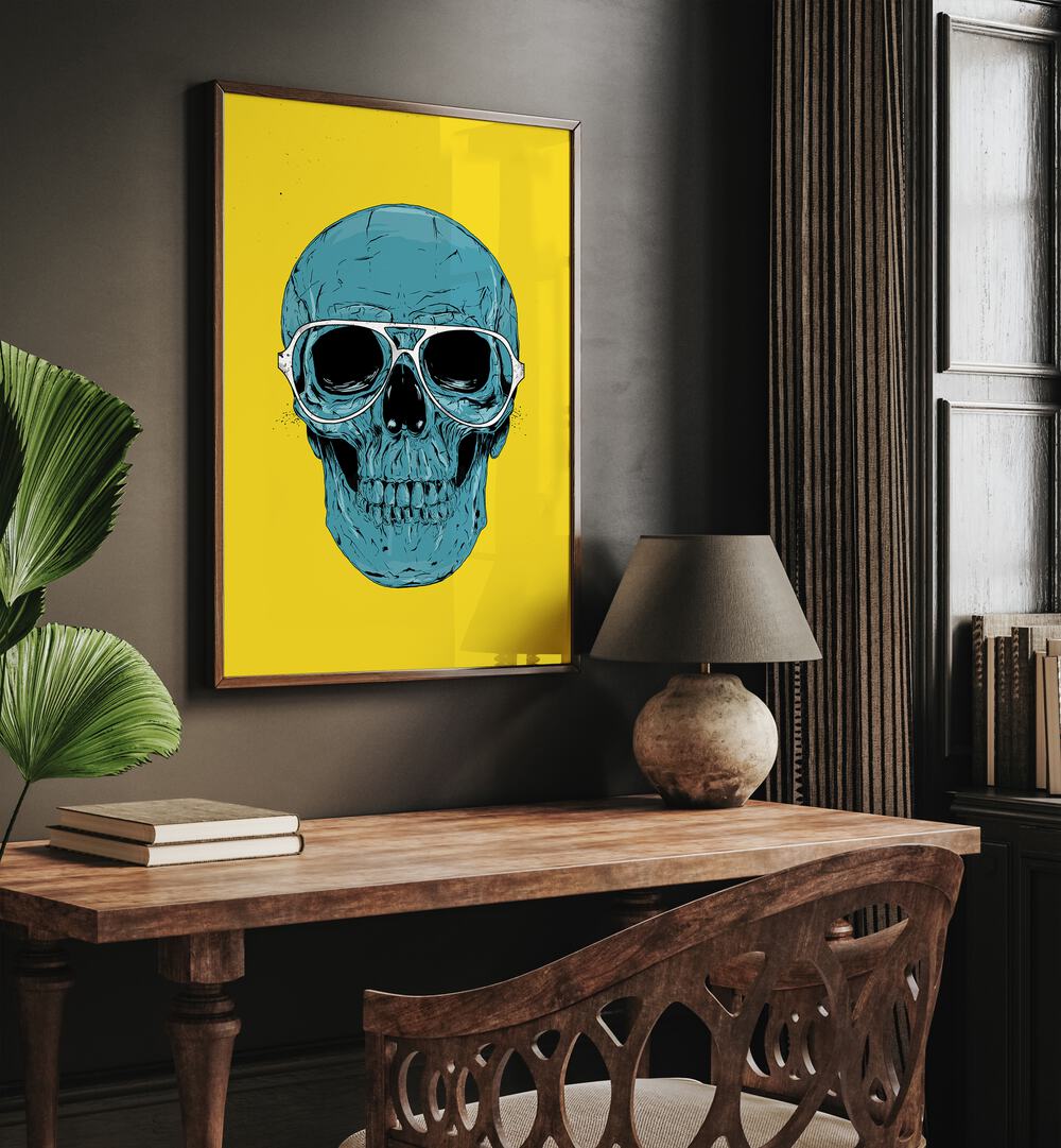 Blue Skull By Balazs Solti Art Prints in Dark Wood Plain Frame placed on a Brown Colored Wall near a Study Table in the Drawing Room