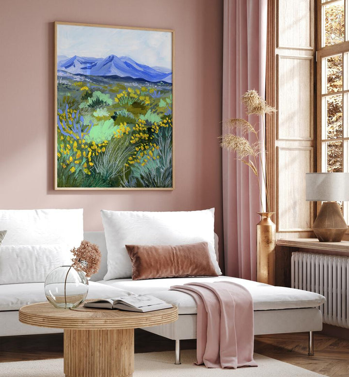 Blue Valley By Sarah Gesek Landscape Art Prints in Oak Wood Plain Frame placed on a living room wall beside a window and behind a sofa