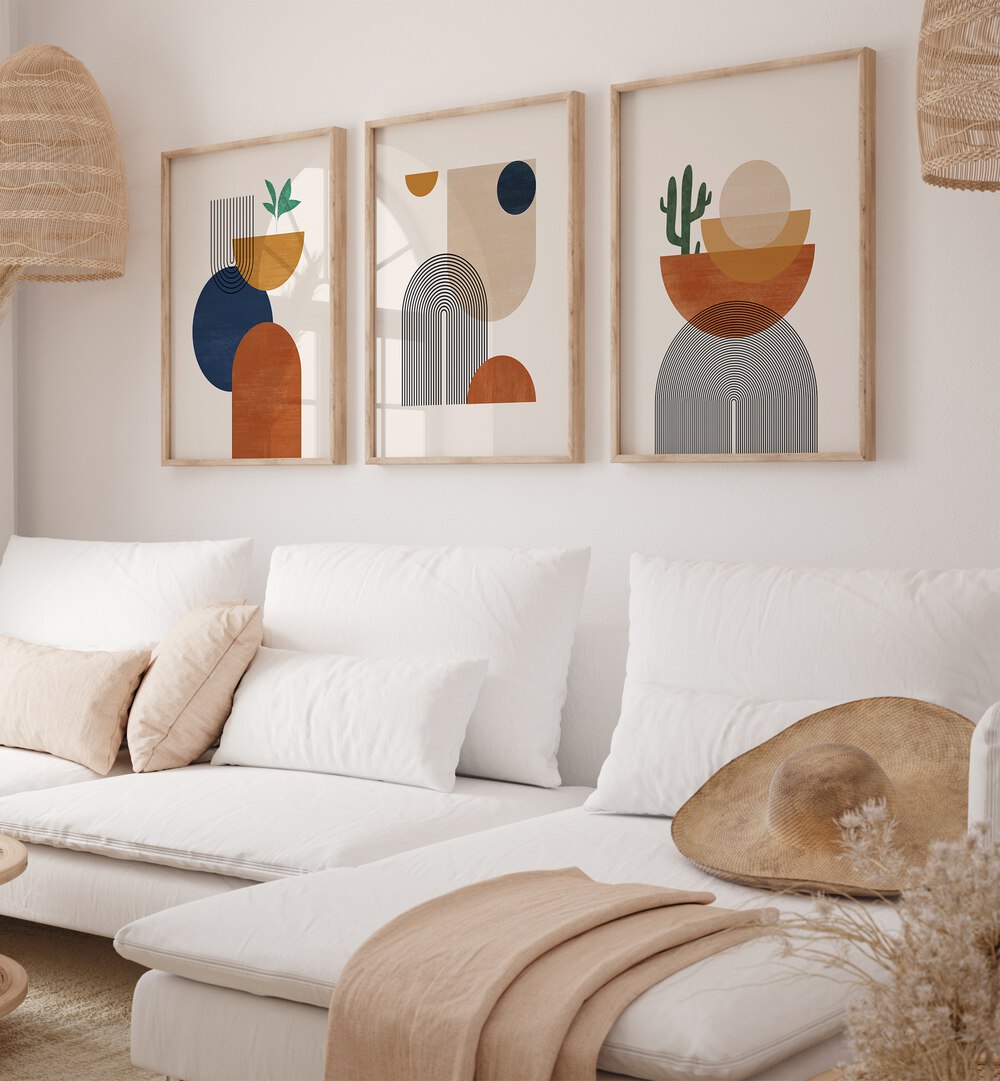 Boho Dessert Geometry Set Of 3 Paintings in Oak Wood Plain Frame placed on a wall living room wall behind a sofa