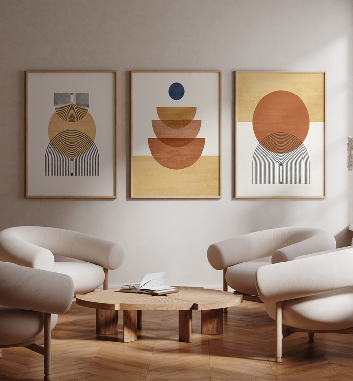 Boho Geometrical Awakenings Set Of 3 Paintings in Oak Wood Plain Frame placed on a wall beside chairs and a table