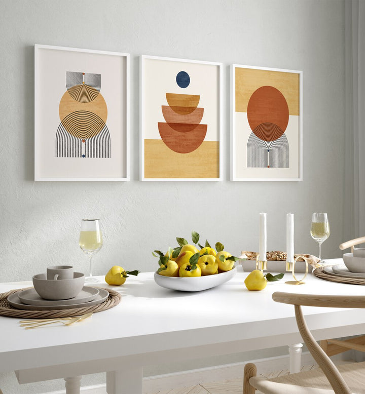 Boho Geometrical Awakenings Set Of 3 Paintings in White Plain Frame placed on a wall behind a dining table  for dining area