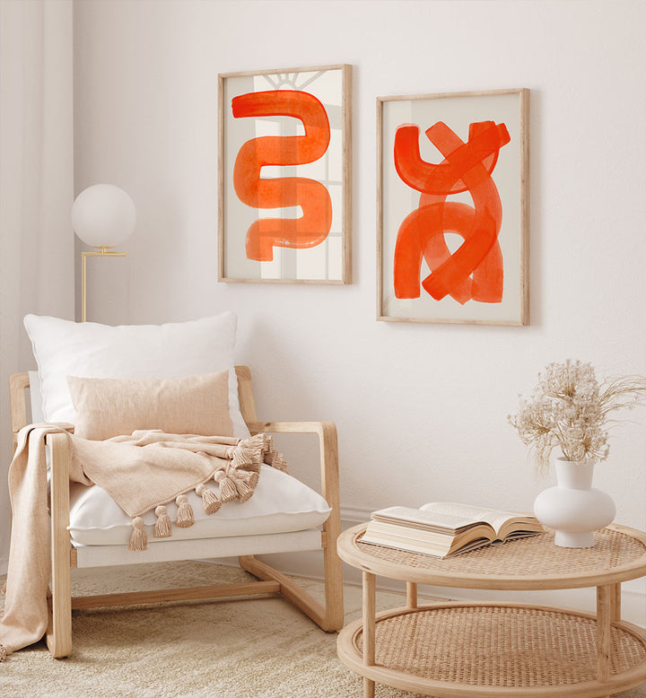 Living room with a wooden armchair, abstract orange art, and a wicker coffee table.