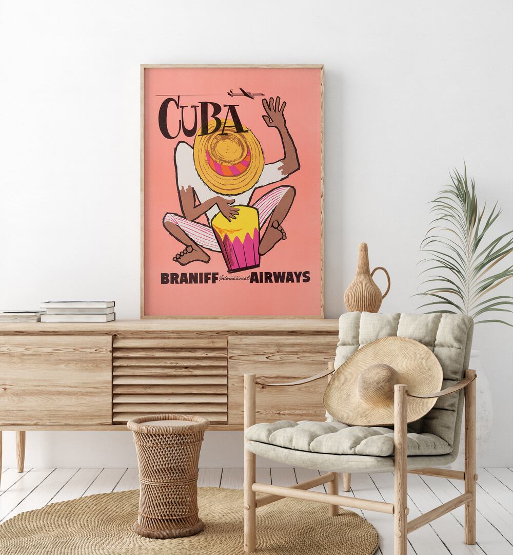 Braniff Airways-cuba  Retro Travel Posters in Oak Wood Plain Frame placed on a console table behind a chair