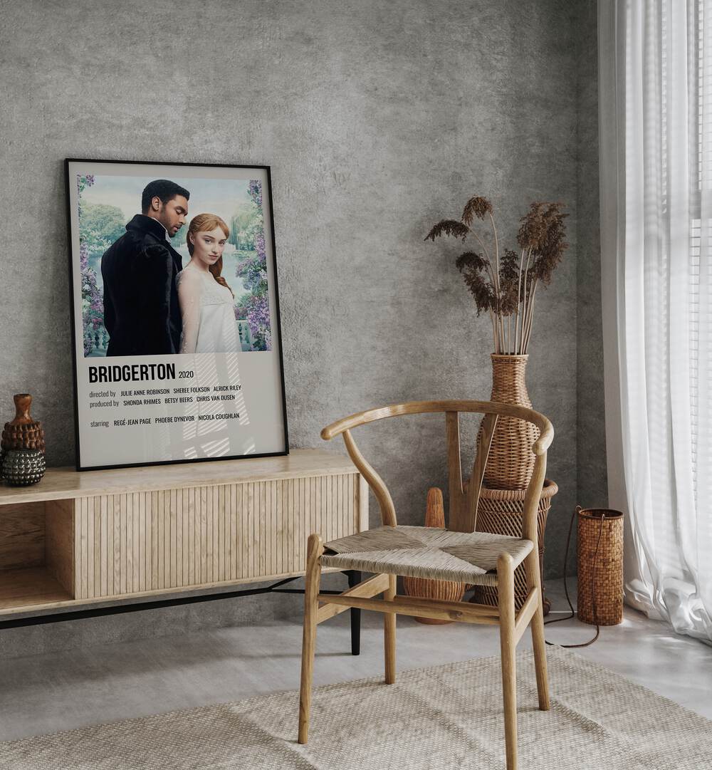 Bridgerton 2020 Movie Posters in Black Plain Frame placed on a table beside oakwood chair