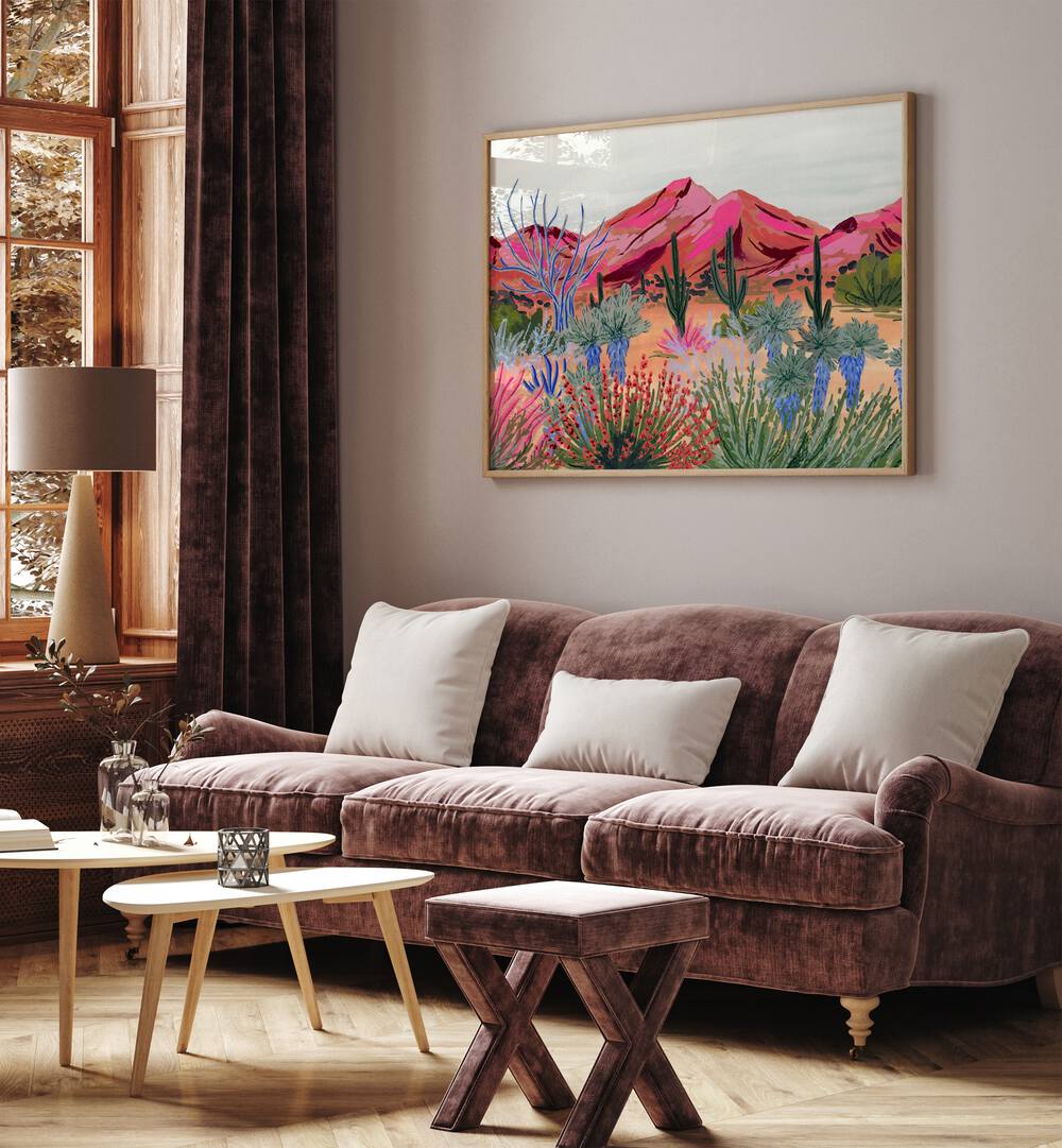 Bright Desert By Sarah Gesek Landscape Art Prints in Oak Wood Plain Frame placed on a living room wall behind a pink sofa and beside a window