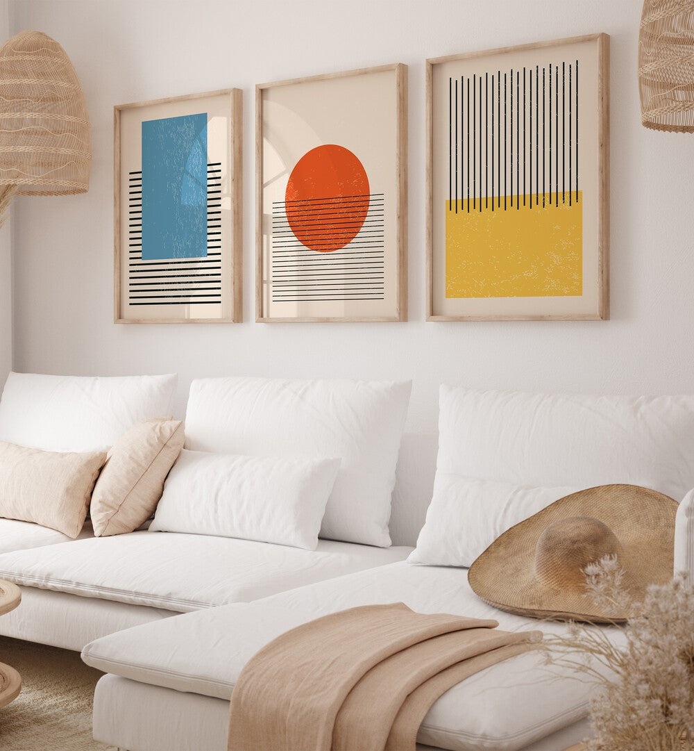 Bright Minimal Set ii Set Of 3 Paintings in Oak Wood Plain Frame placed on a living room wall behind a sofa