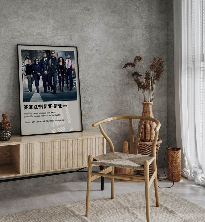 Brooklyn Nine-nine 2013 Movie Posters in Black Plain Frame placed on a table beside oakwood chair