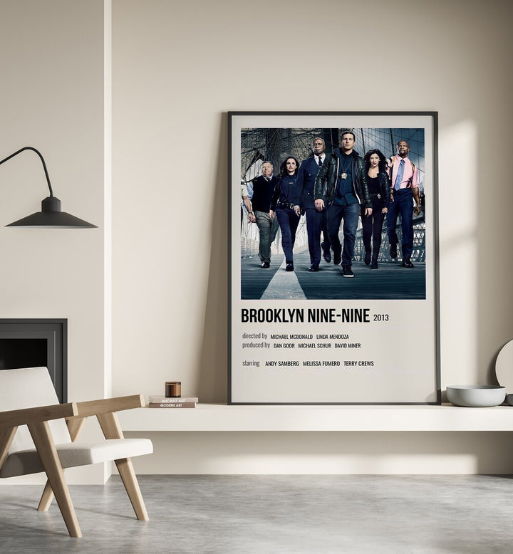 Brooklyn Nine-nine 2013 Movie Posters in Black Plain Frame place on a wall behind a chair beside lamp