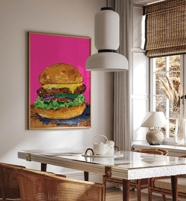 Burger Pink by Alice Straker Cafe Art Prints Cafe Posters in Oak Wood Plain Frame placed on a wall in a dining room area beside a window and behind a dining table