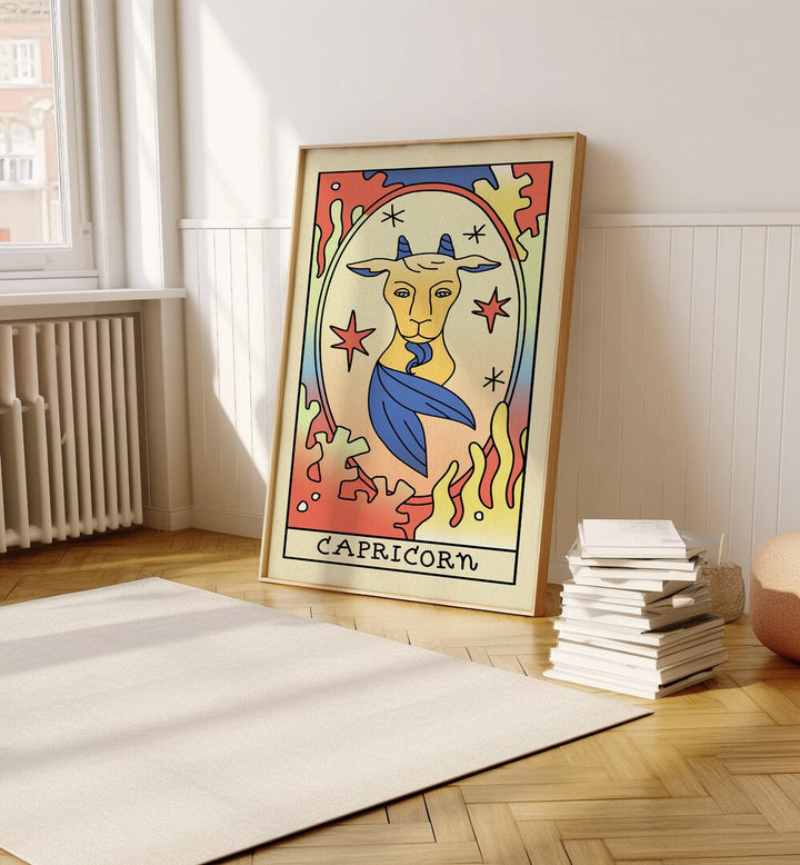 Capricorn Zodiac & Tarot Art Painting Artwork in plain oakwood frame beside a stack of books