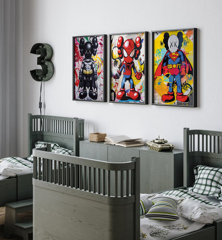 Cartoon Superhero Set Set Of 3 Paintings in Black Plain Frame placed on a kids bedroom wall behind a console table and between two beds