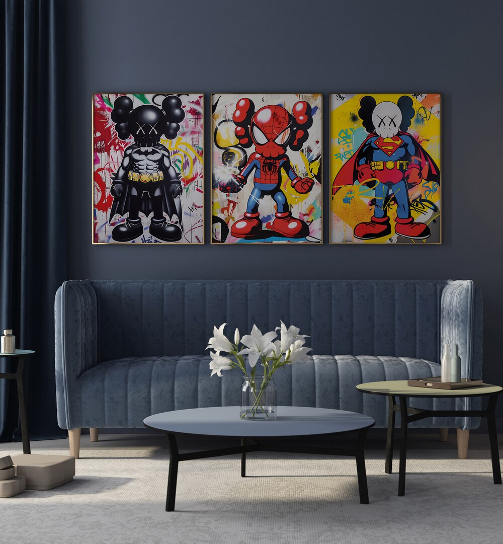 Cartoon Superhero Set Set Of 3 Paintings in Oak Wood Plain Frame placed on a living room wall behind a blue sofa