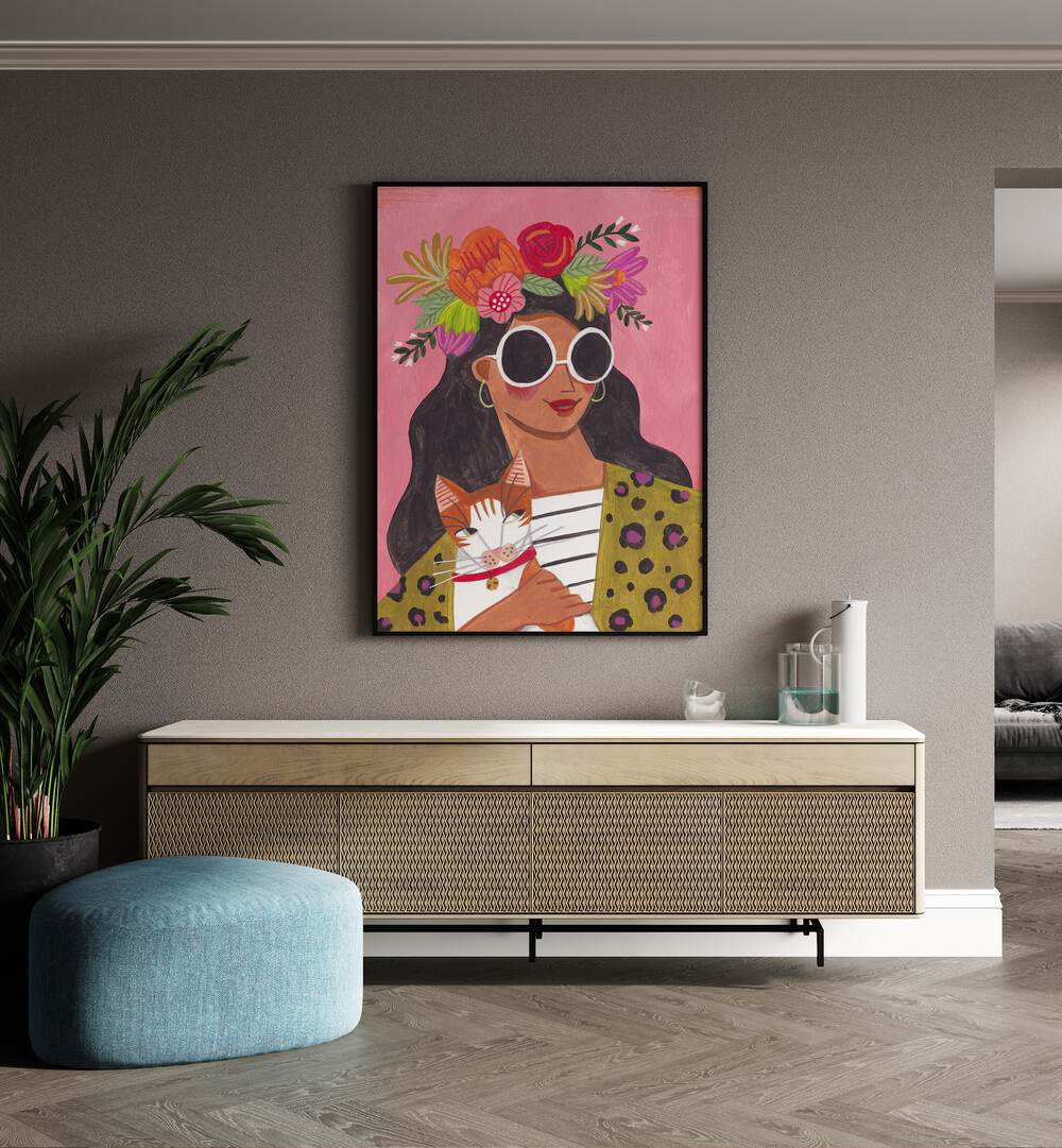 Cat Lady II By Caroline Bonne Muller Women Paintings in Black Plain Frame on a wall above a console table beside a plant