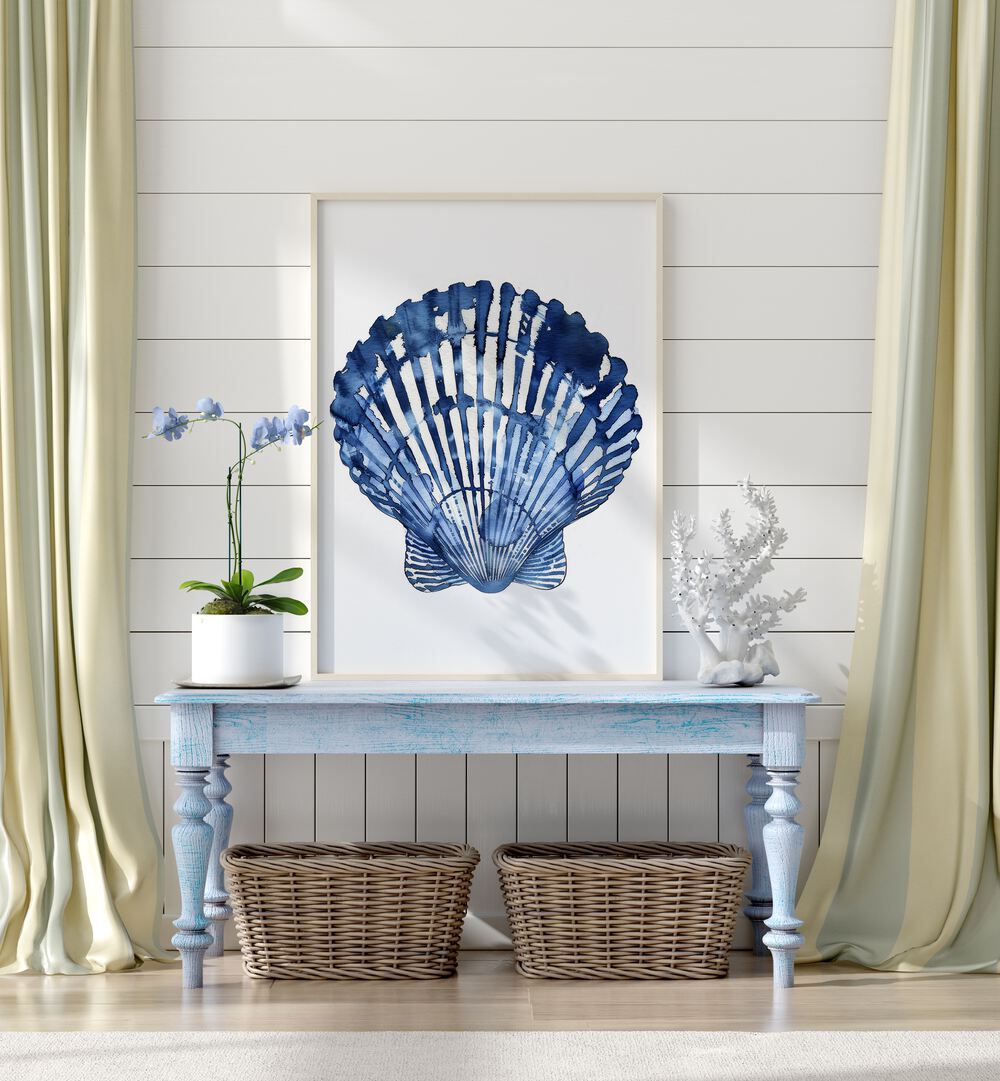 Cerulean Conch I Beach Prints Coastal Wall Art in White Plain Frame placed on a blue table beside a plant and a showpience