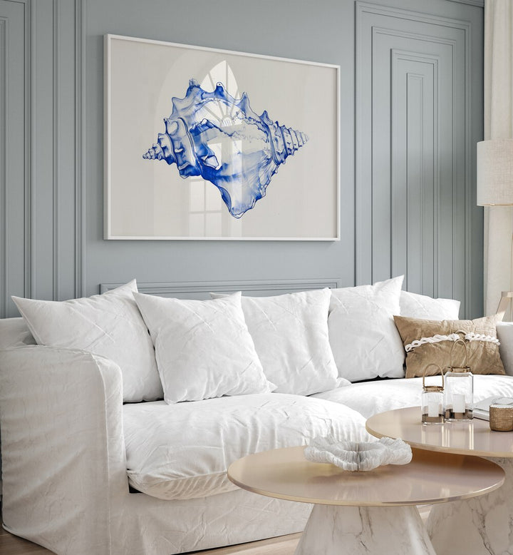 Cerulean Conch Iv Beach Prints Coastal Wall Art in White Plain Frame placed on a wall behind a white sofa for living room