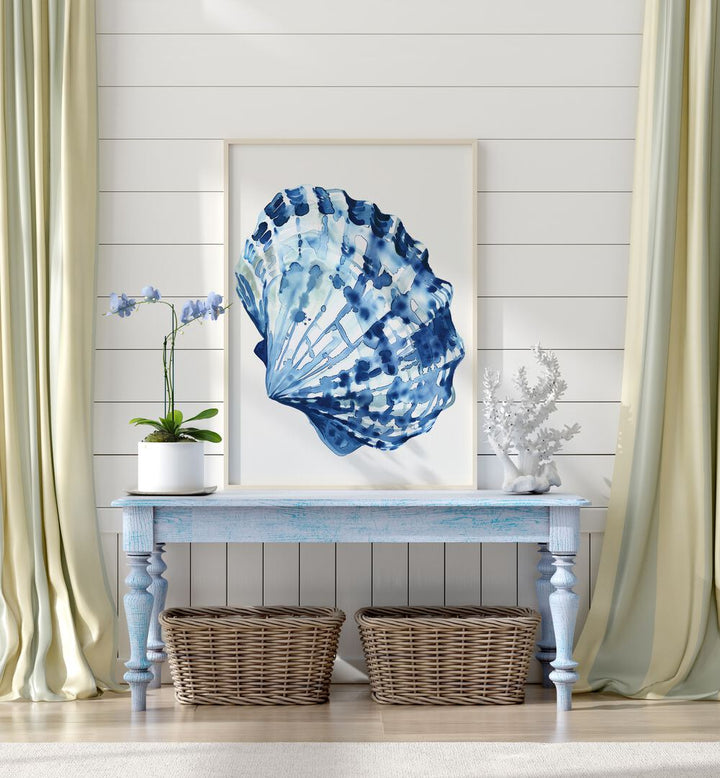 Cerulean Conch ii Beach Prints Coastal Wall Art in White Plain Frame placed on a blue table beside a plant and a showpiece