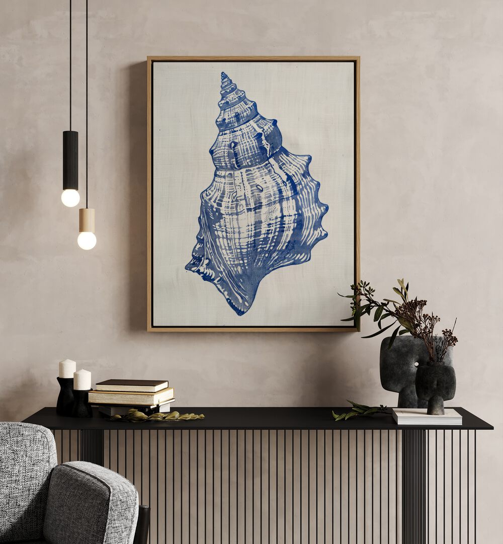 Cerulean Conch iii Beach Prints Coastal Wall Art in Oak Wood Floater Frame placed on a wall behind a black table