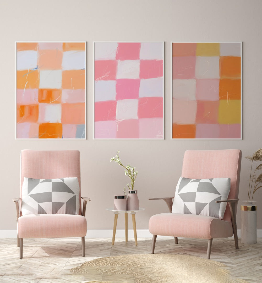 Checkered Colors Set Of 3 Paintings in White Plain Frame placed on a wall behind pink chairs and a table