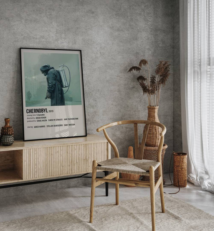 Chernobyl 2019 i Movie Posters in Black Plain Frame placed on a table beside oakwood chair