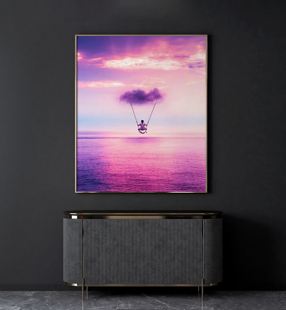 Cloud Swing By Ritvik Takkar Surreal Art Prints in Gold Plain Frame placed on a Dark Grey Colored Wall above a Console Table in the Drawing Room