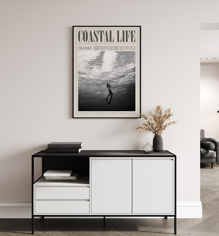 Coastal Life i Beach Prints Coastal Wall Art in Black Plain Frame placed on a white wall behind a black and white table